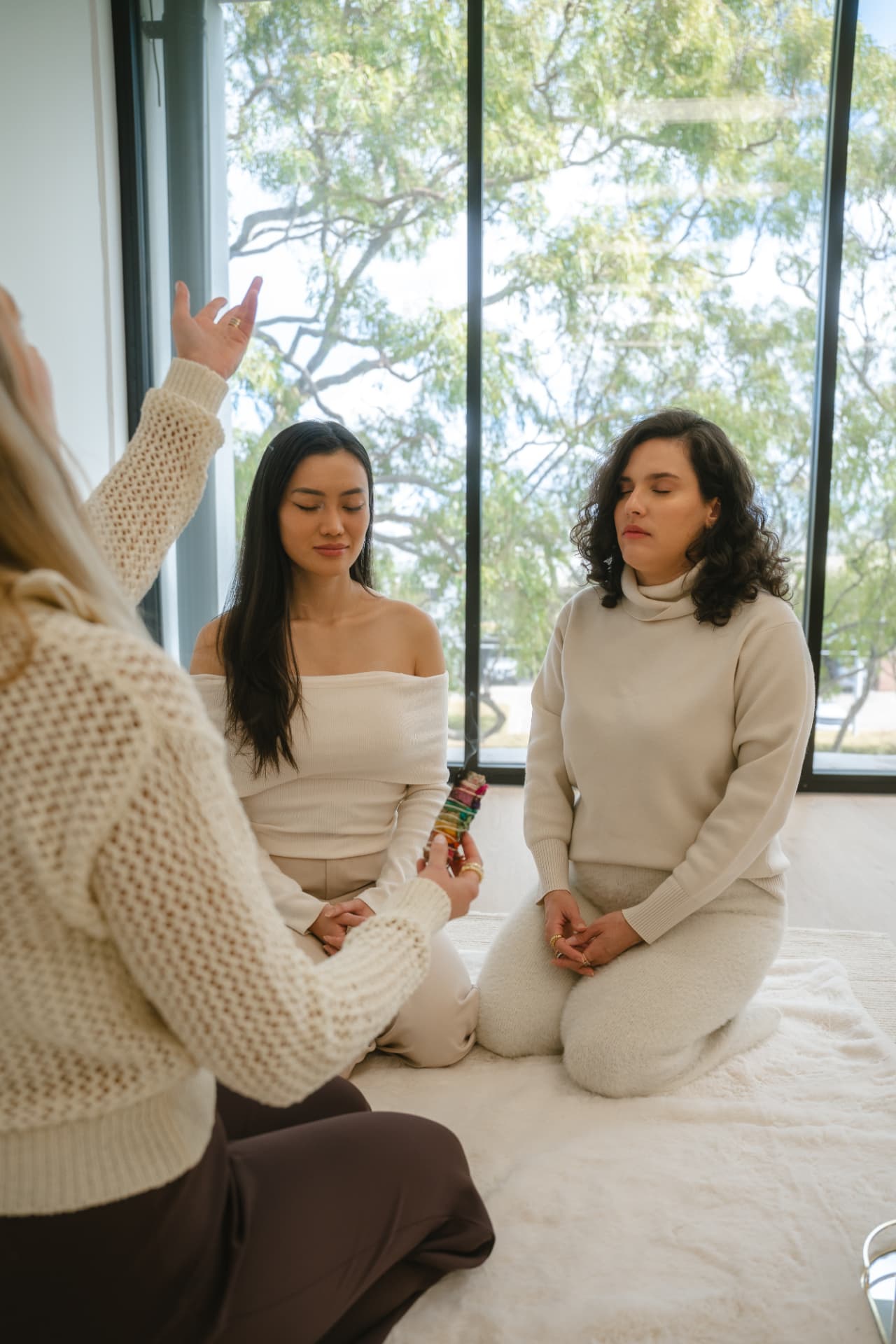 A small Reiki circle practising together in a light-filled room